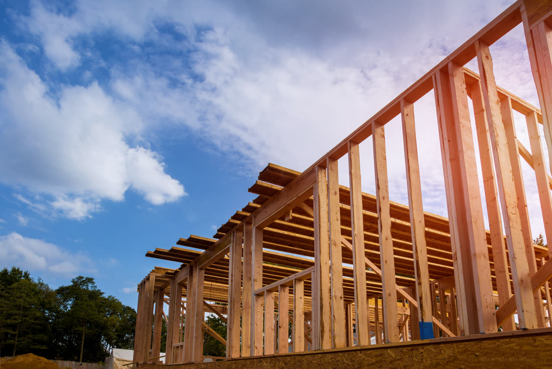 House being framed, walls up and rafters open to the sky